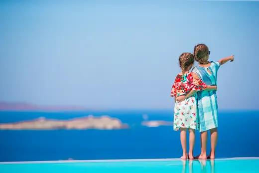 Zwei kleine Mädchen am Beckenrand mit Blick aufs Meer